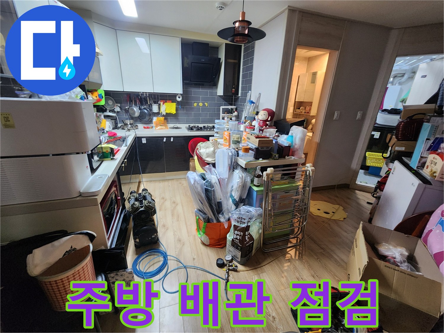 누수 탐지를 위해 주방 주변을 정리하고 장비를 준비한 현장 사진입니다.