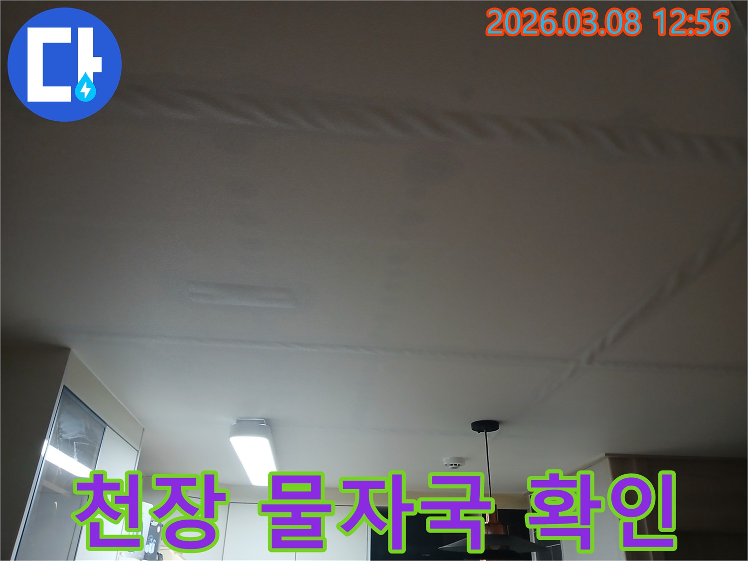 주방 천장에 물이 새어-얼룩지고 변색된-누수 현장을 보여주는 사진