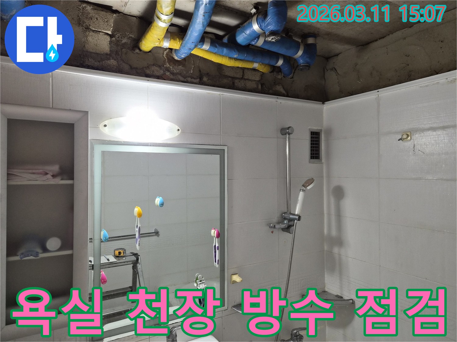 욕실 천장 내부의-파란색과 노란색 배관들이-꼼꼼한 누수 점검을 위해-노출되어 있는 모습