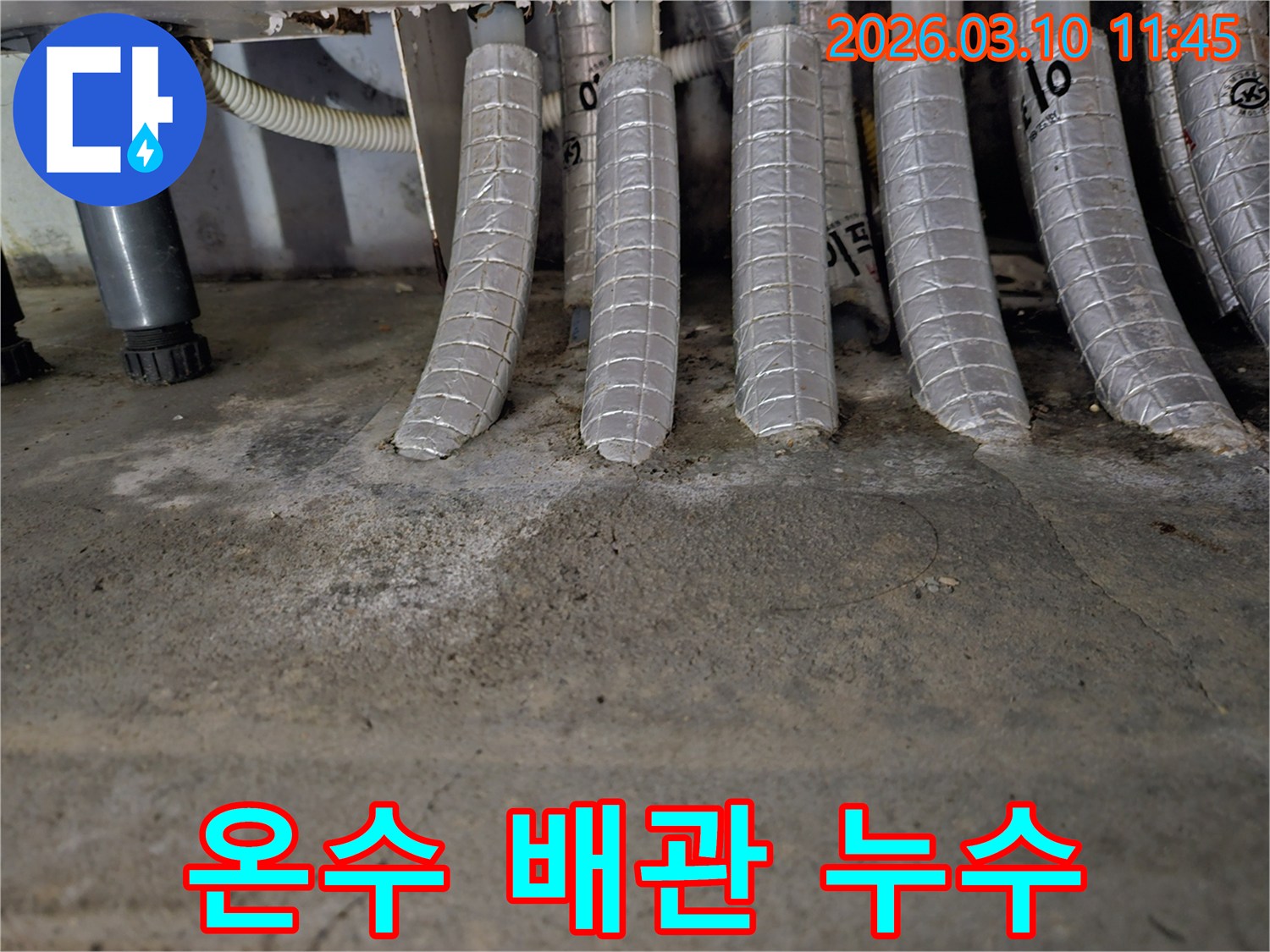 콘크리트-바닥에-단열된-온수-배관들이-연결된-지점에서-발견된-물-자국과-백화-현상을-촬영한-사진입니다