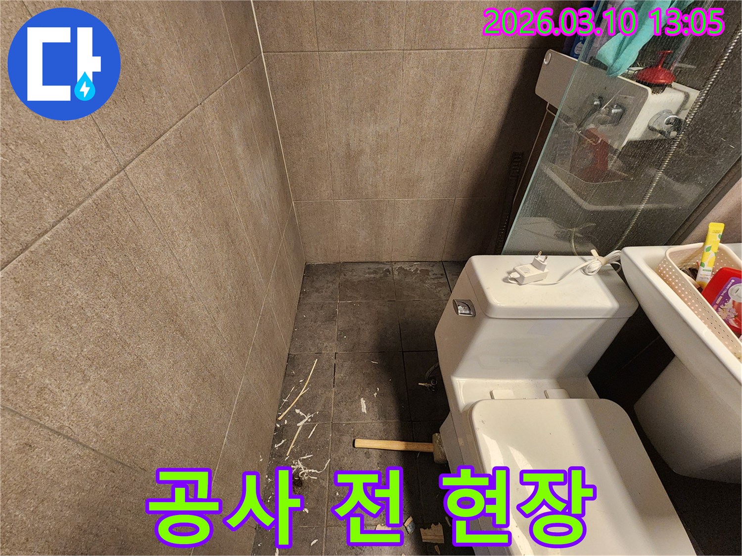 난계로 아파트 욕실의-누수 공사 전 상태를 보여주며-바닥 손상과-변기 분리 흔적이 보입니다