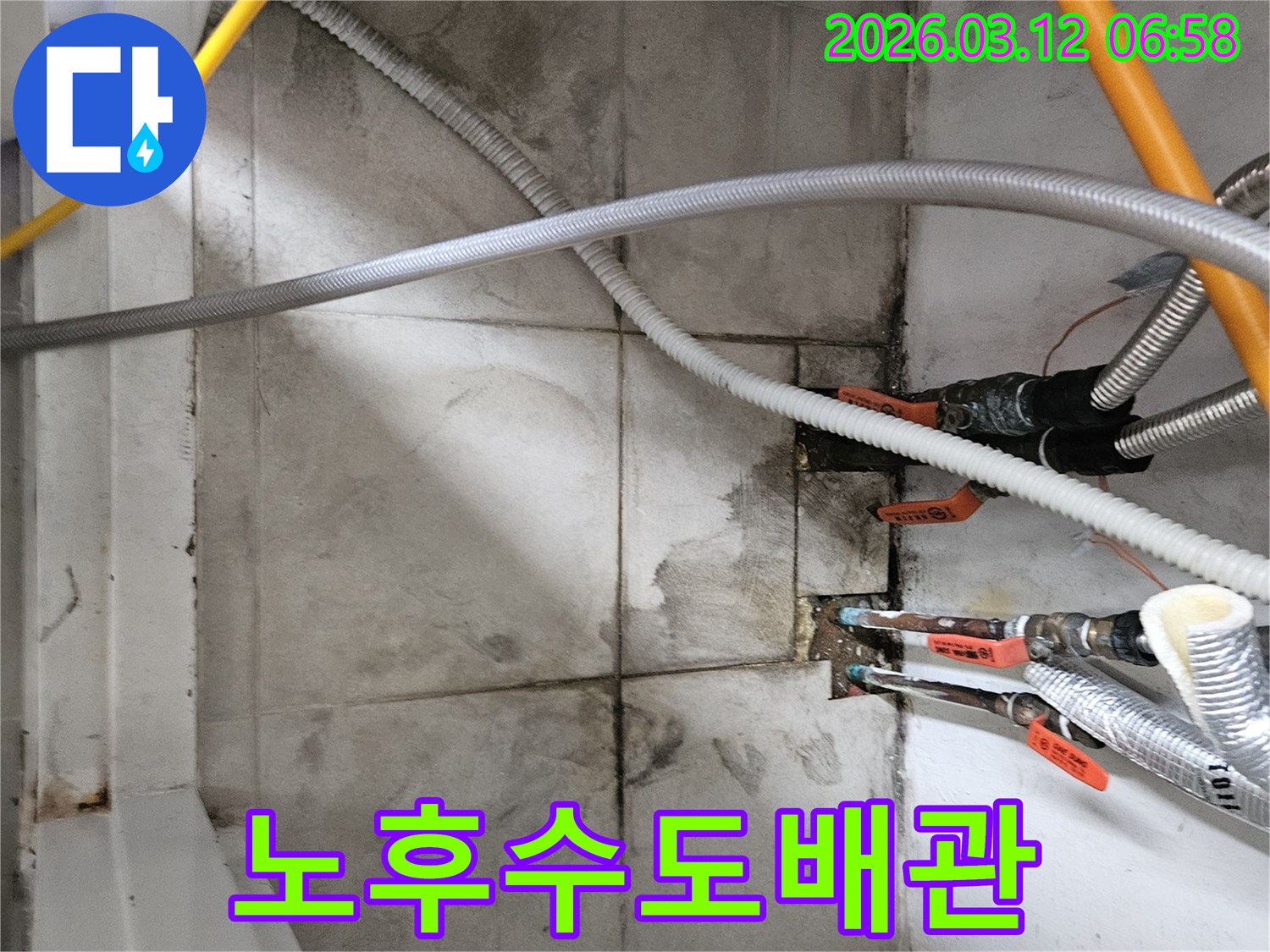 노후된-수도-배관-주변의-물-자국과-습기를-확인하며-압력-테스트를-준비하는-모습