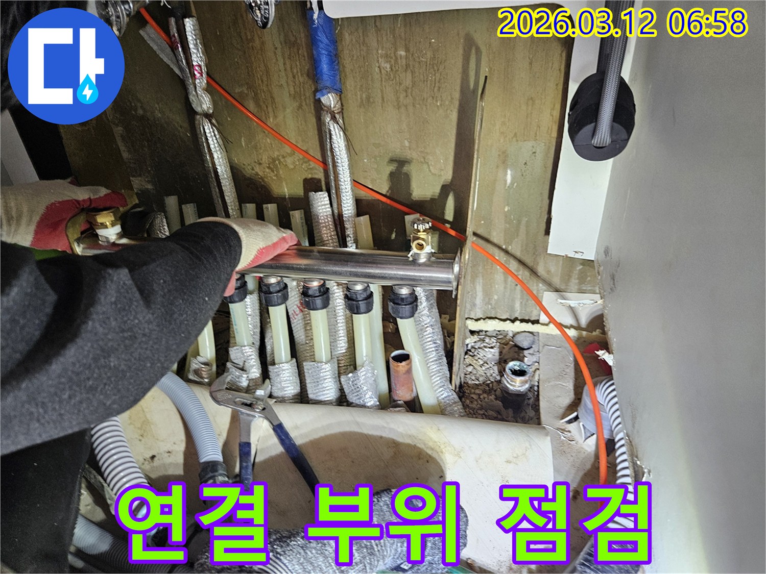 마포구-주택의-보일러-분배기-연결-부위를-전문가가-정밀하게-점검하는-모습입니다