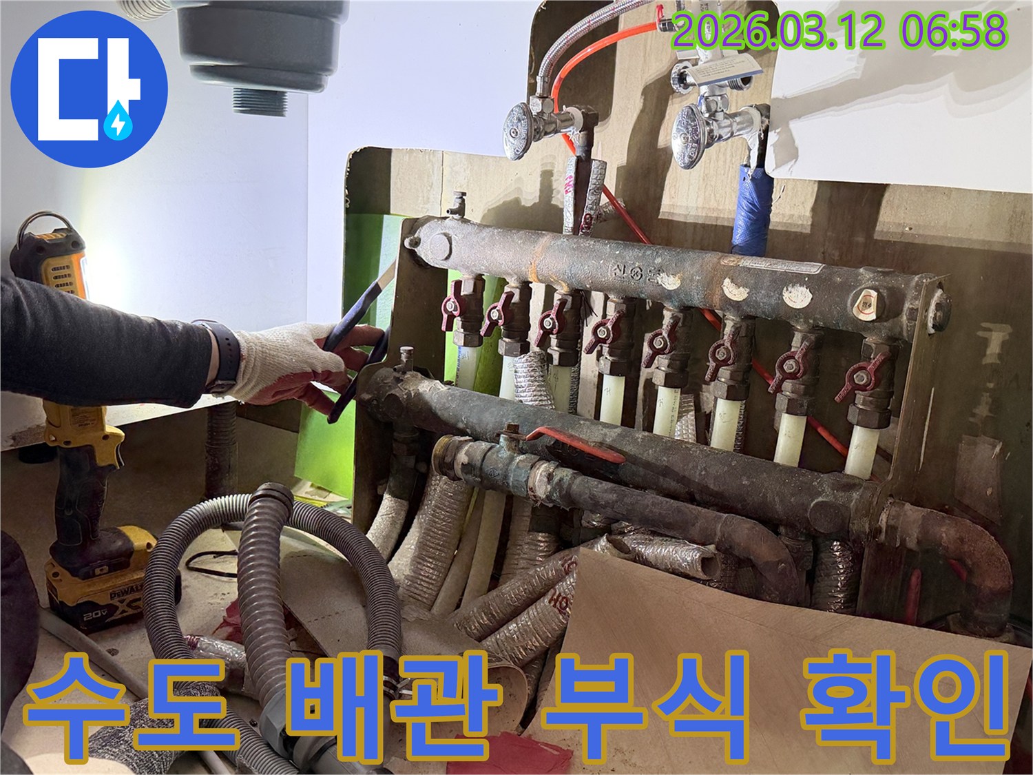 숙련된-엔지니어가-빌라-수도-배관의-연결-부위에서-발생한-부식-상태를-정밀하게-확인하는-모습