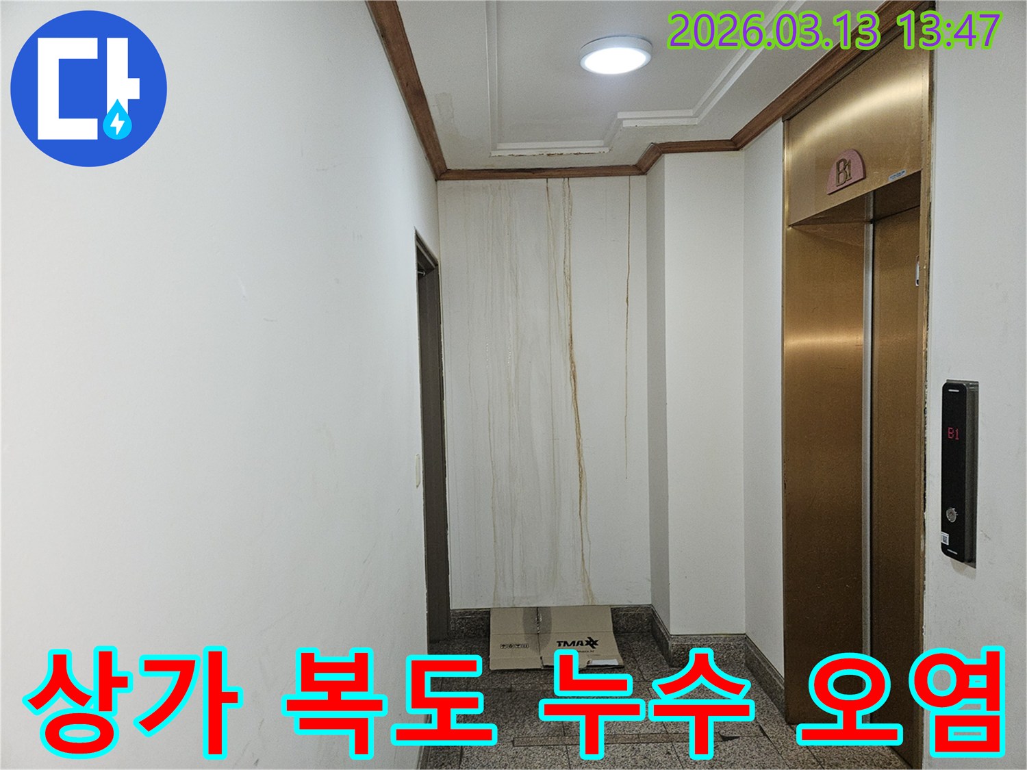 이 사진은 상가 복도 벽면에 발생한 누수로 인해-물이 흘러내려 심하게 오염된 모습을 보여줍니다-천장과 벽의 경계에서 누수가 시작된 것으로 보입니다
