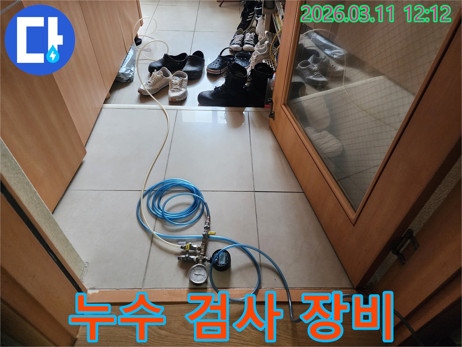 누수 탐지 작업을 위해 압력 게이지와 연결 호스를 바닥에 설치한 모습