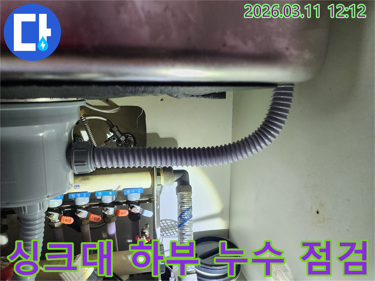 싱크대 하부 공간에서-배수관과 급수관의-연결 상태를-확인하는 작업 사진입니다