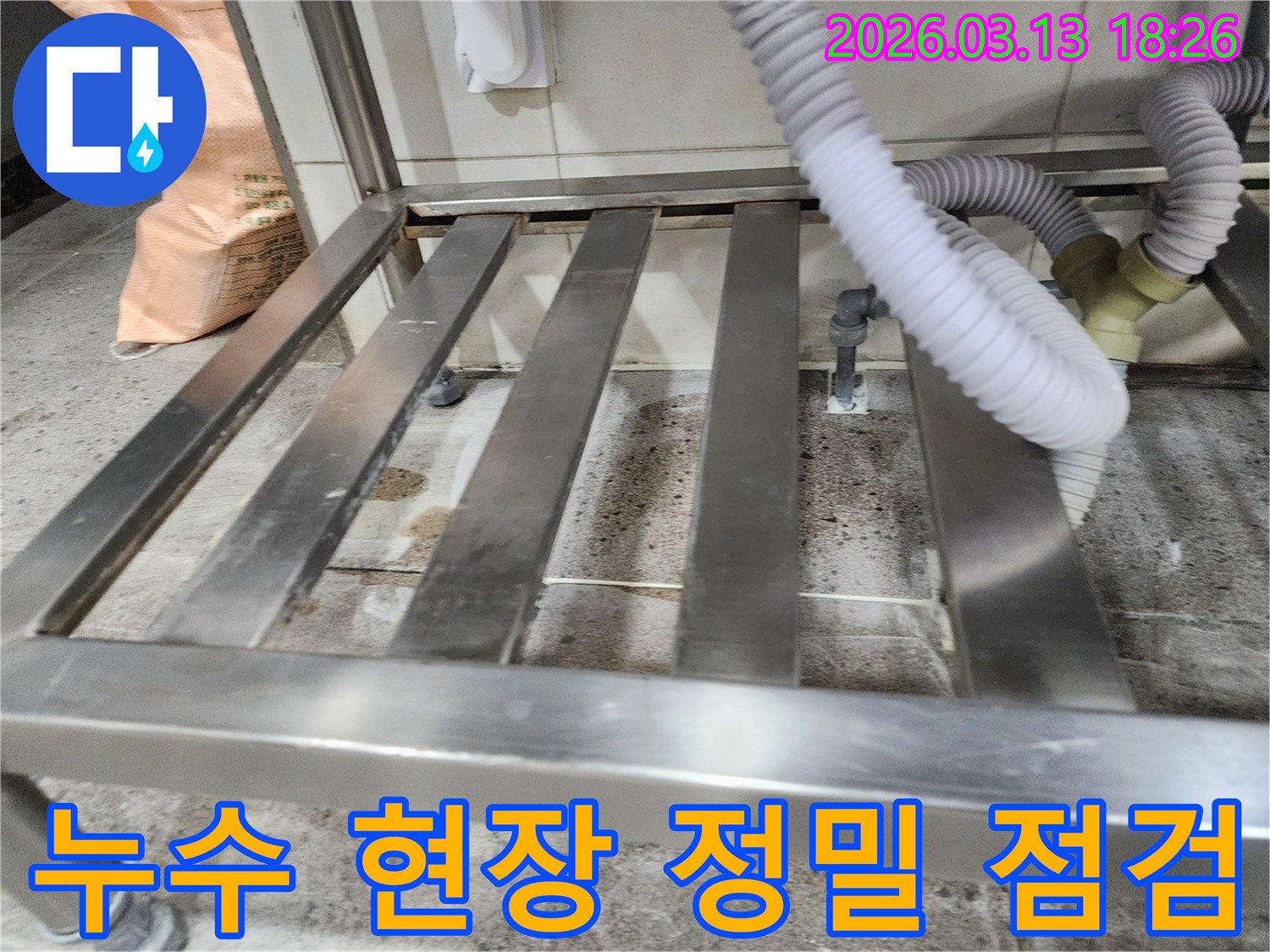 누수-발생 현장에서-배수 호스와-연결된 배관 주변의-습기와 오염을-꼼꼼하게 확인하는-엔지니어의 모습
