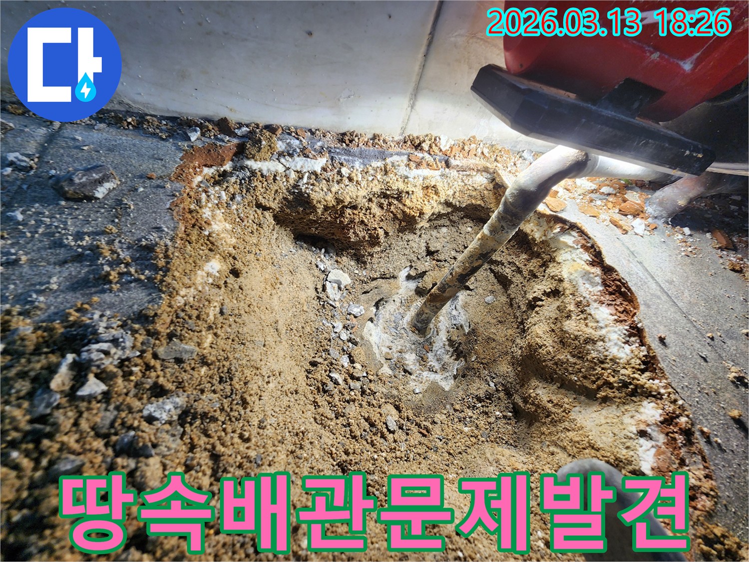 땅속에 매설된 배관에서-누수가 발생하여-주변 흙이 젖고-하얀 침전물이 보이는 현장입니다