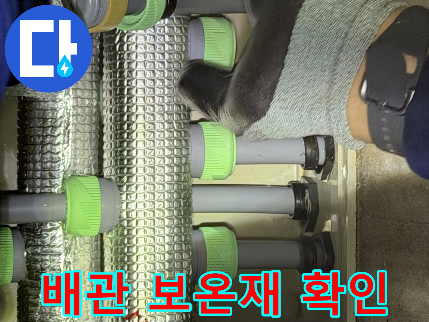 은박 보온재로 덮인-수도 배관 연결 부위 근접 사진