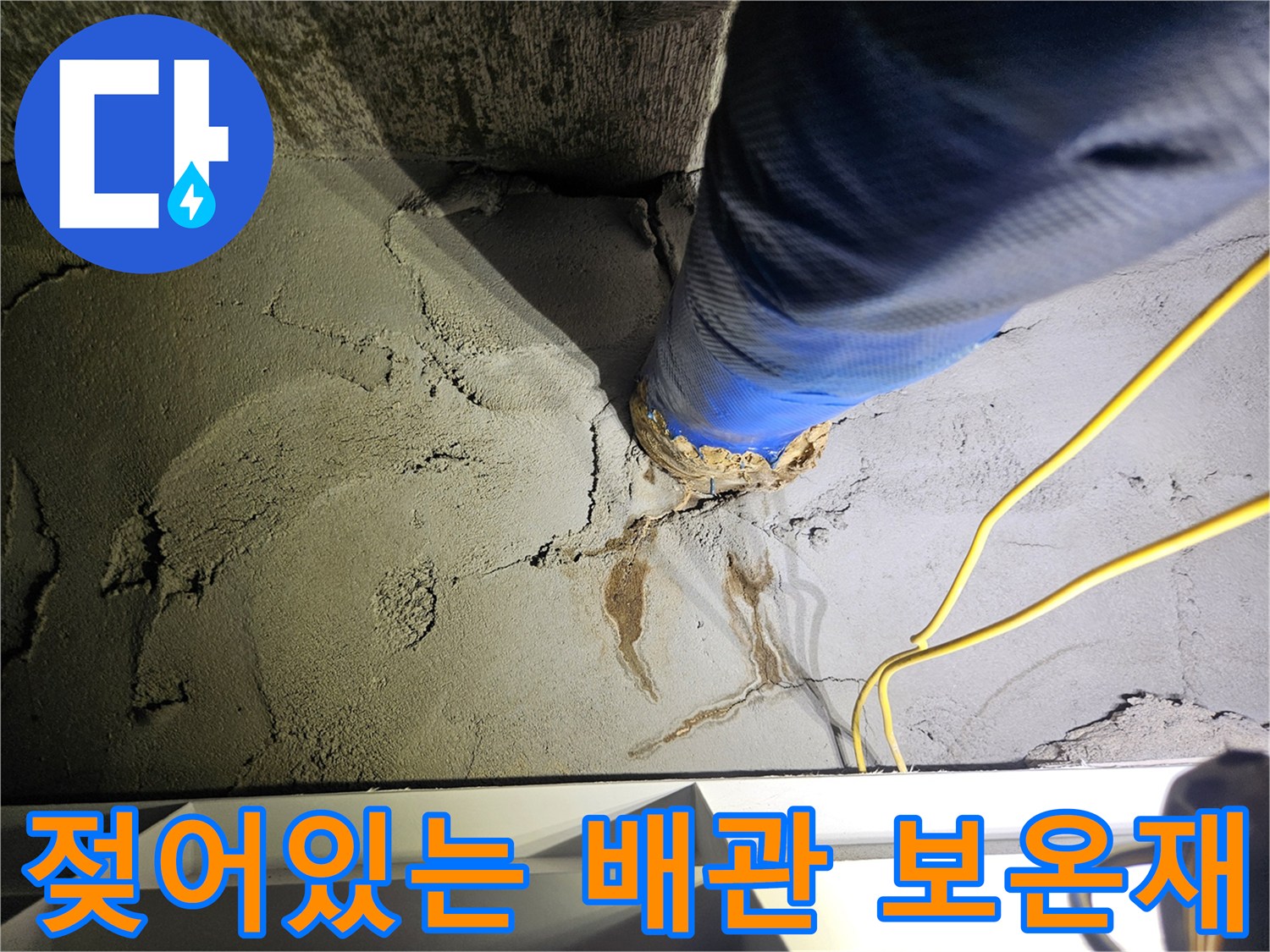 파란색 보온재로 감싸진 배관-주변부의 젖은 콘크리트 벽면