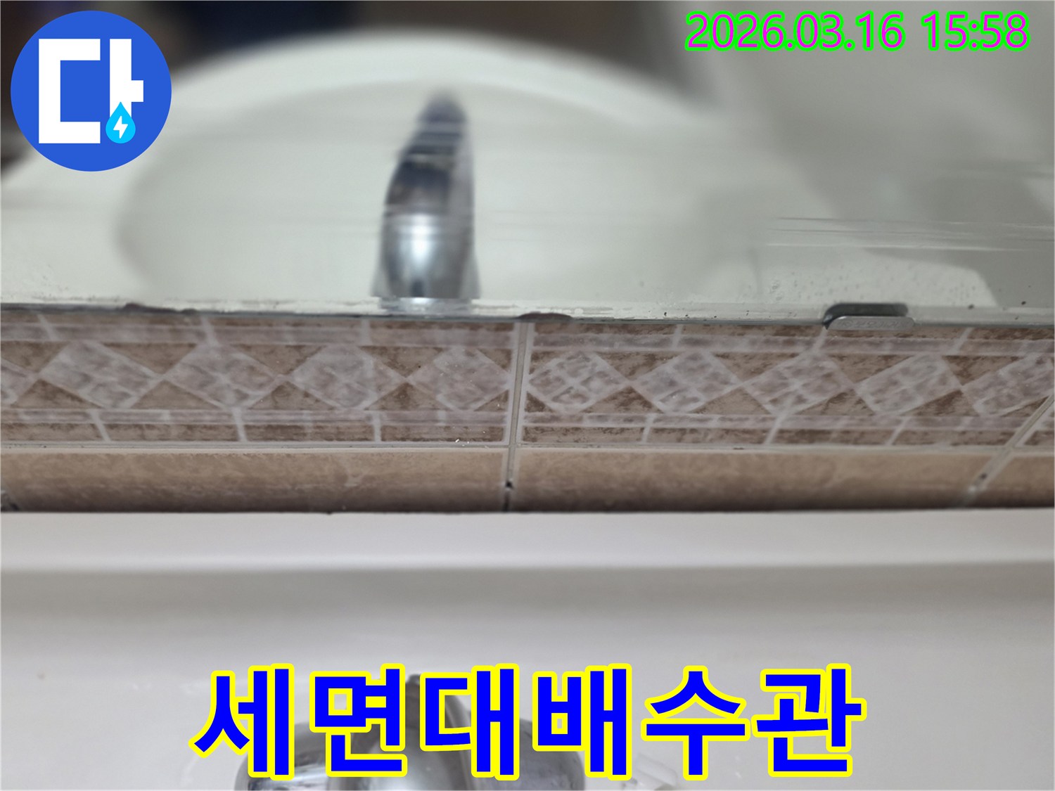 세면대-배수관-주변의-타일-손상과-누수-흔적을-보여주는-클로즈업-사진