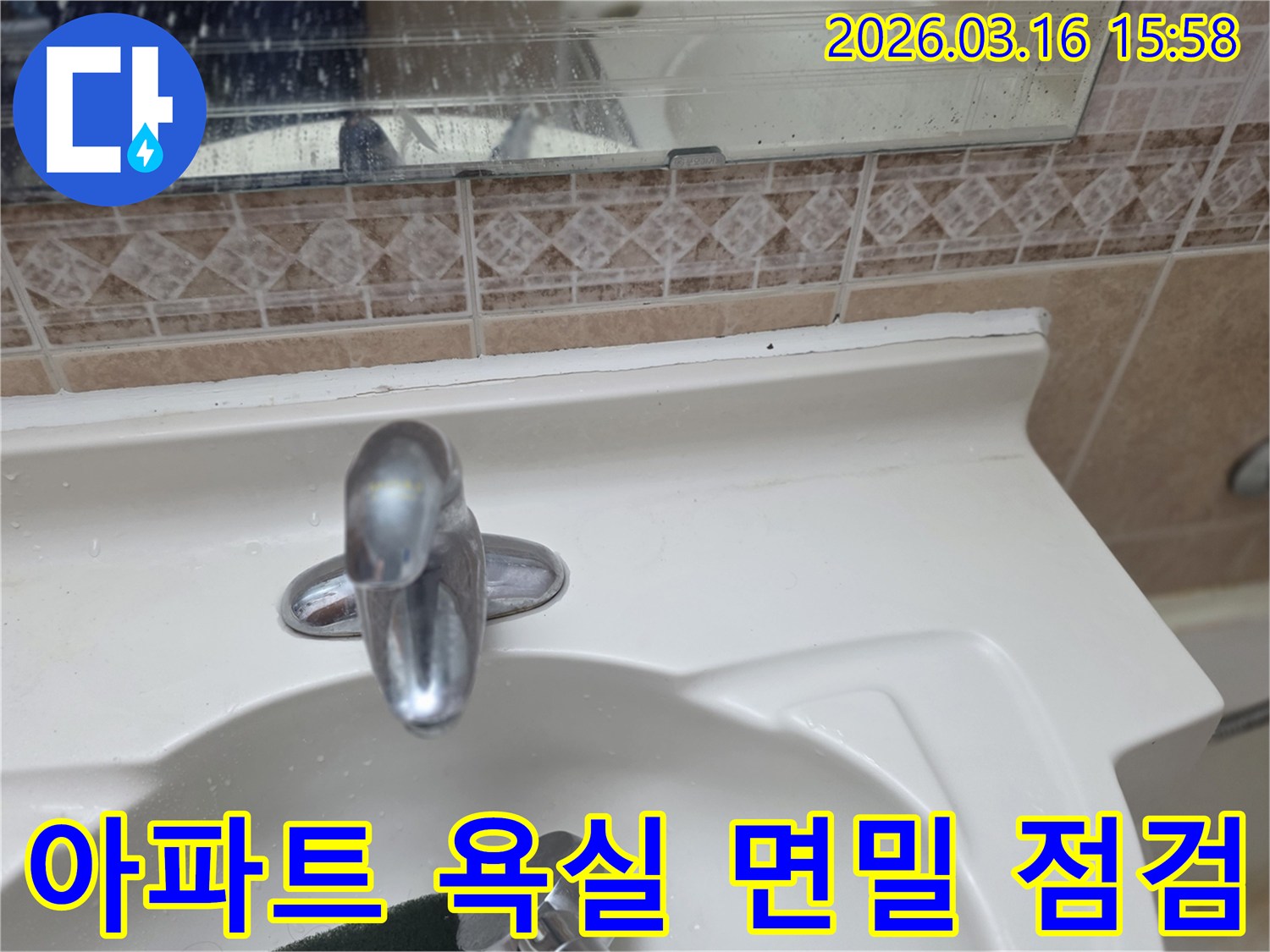 아파트-욕실-세면대-수전과-주변-타일-거울의-전반적인-상태를-면밀히-점검하는-모습