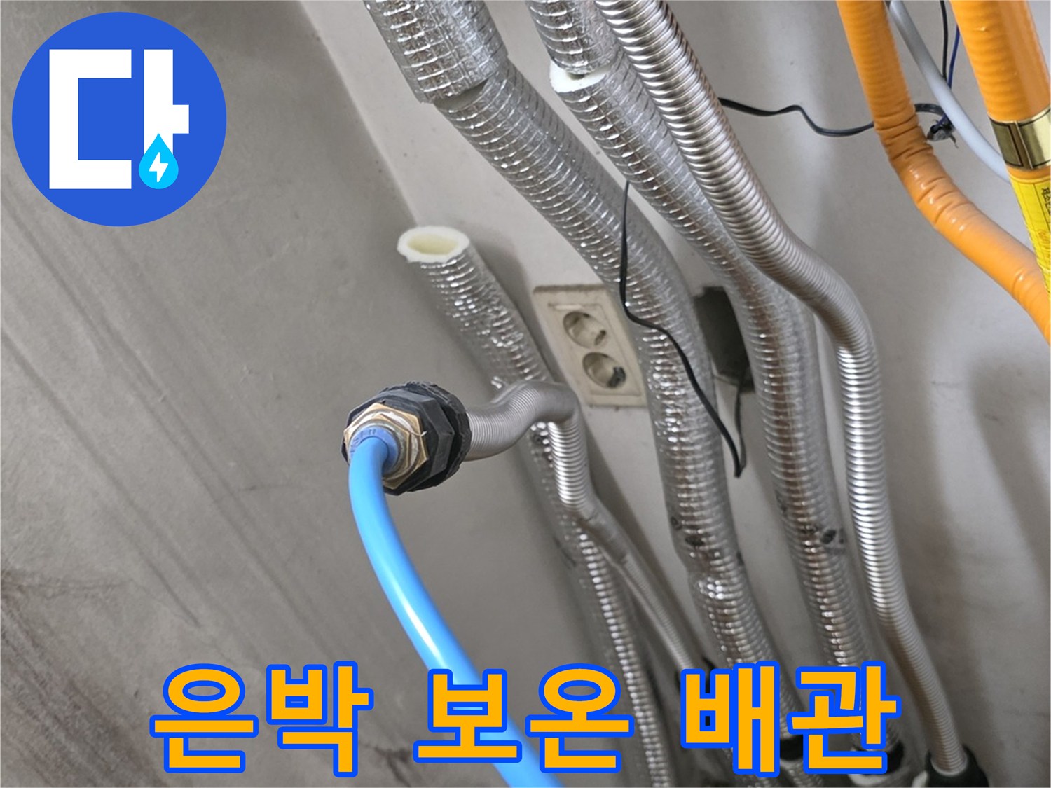 보일러 하단에 연결된 여러 가닥의 은박 보온재 배관들