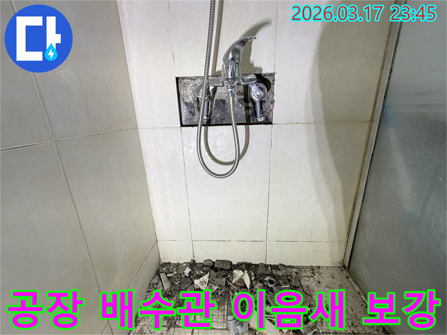 경기 화성시 병점구 공장 샤워실에서-배수관 이음새 누수 부분 교체 및 방수 보강을 위해-바닥 타일이 파손된 채로-공사가 진행 중인 모습입니다.