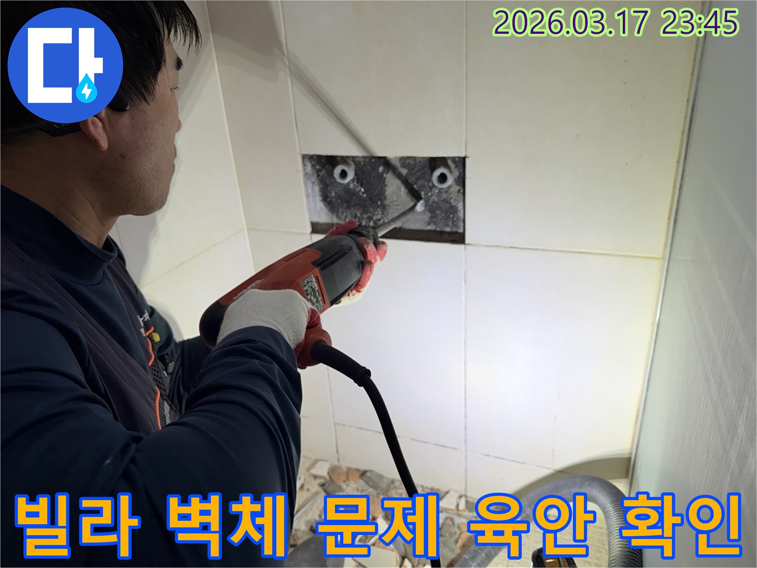 누수 공사 전문가가 빌라 욕실 벽면의 타일을 조심스럽게 파쇄하여-누수 원인 배관의 문제점을 육안으로 확인하는 모습입니다.