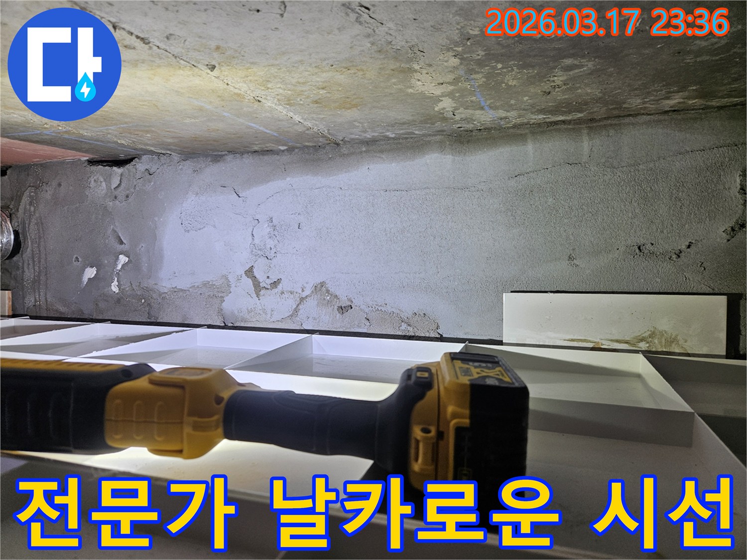 누수 전문 엔지니어가-천장 누수 현장에서-플래시를 이용해-세밀한 육안 검사를 진행하며-누수의 단서를 찾고 있습니다.