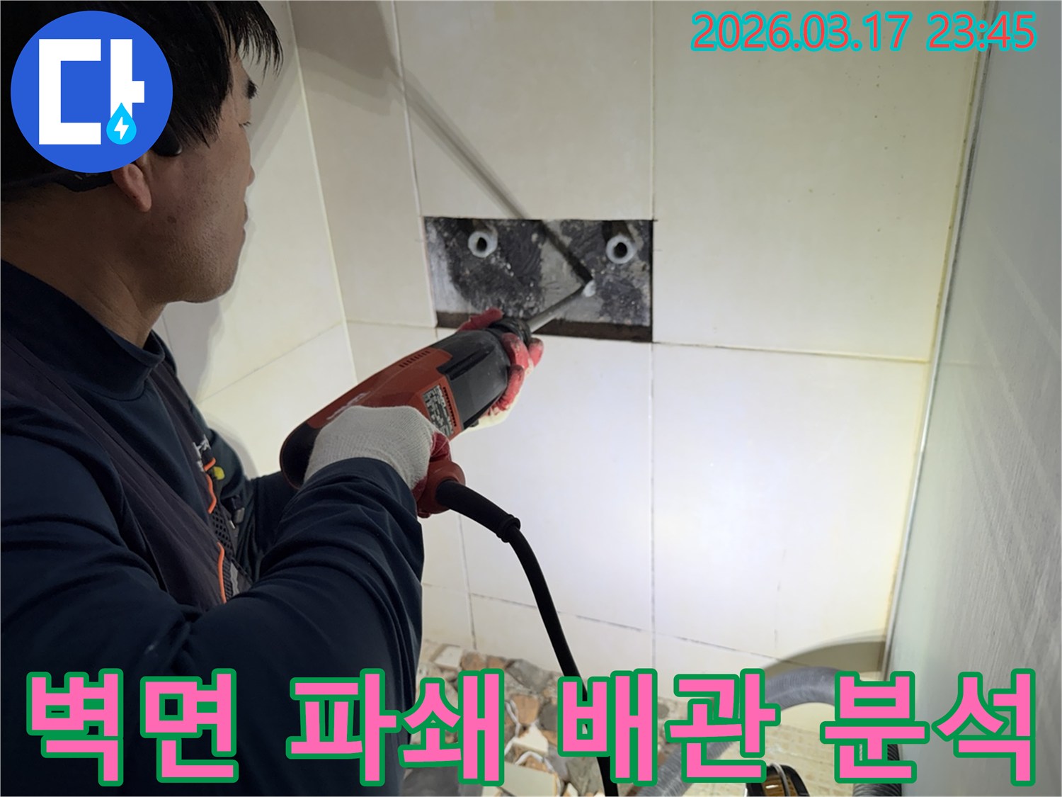 누수 전문가가 벽면 타일을 깨끗하게 파쇄하며-누수 원인인 배관의 문제점을 정밀하게 진단하고 분석하는 작업을 진행 중입니다.