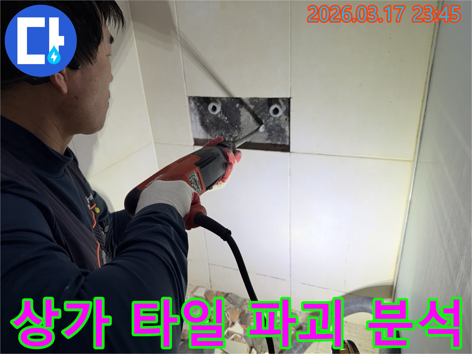 누수 전문가가 상가건물 벽면 타일을 파괴하여-숨겨진 배관의 누수 지점을 정밀하게 분석하는 작업 현장입니다.