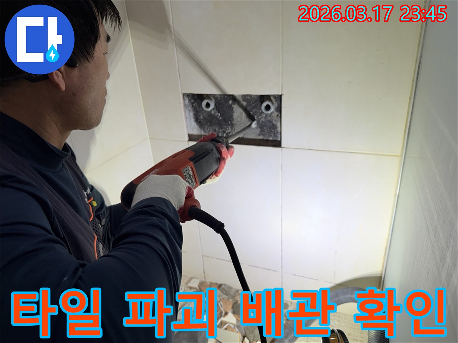 누수 전문가가 욕실 벽면 타일을 파괴하여-숨겨진 배관의 누수 지점을 육안으로 확인하는 작업 현장입니다.