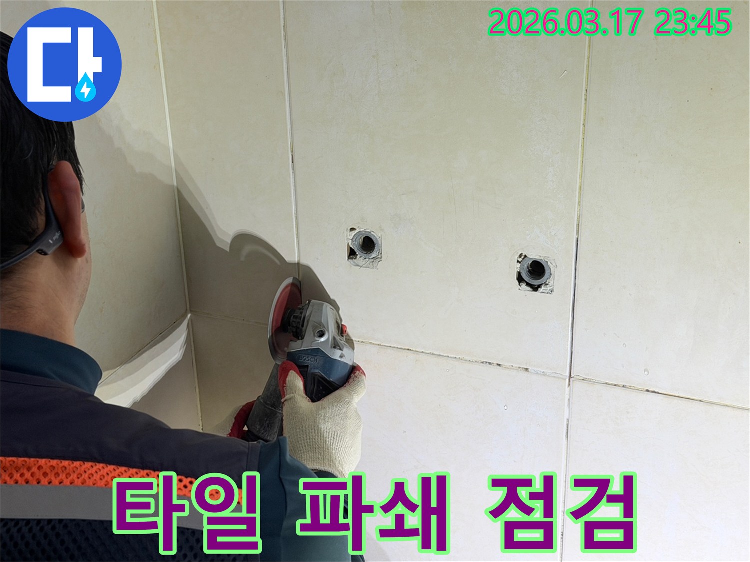 누수 지점 확인 후-전문가가-타일 벽면을-파쇄하고-배관을-점검하는-작업을-진행하고-있습니다