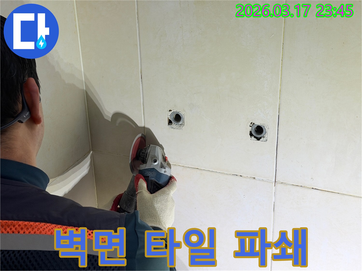누수공사 현장에서-엔지니어가-배관 확인을 위해-벽면 타일을-안전하게-파쇄하는-작업을-진행하고-있습니다