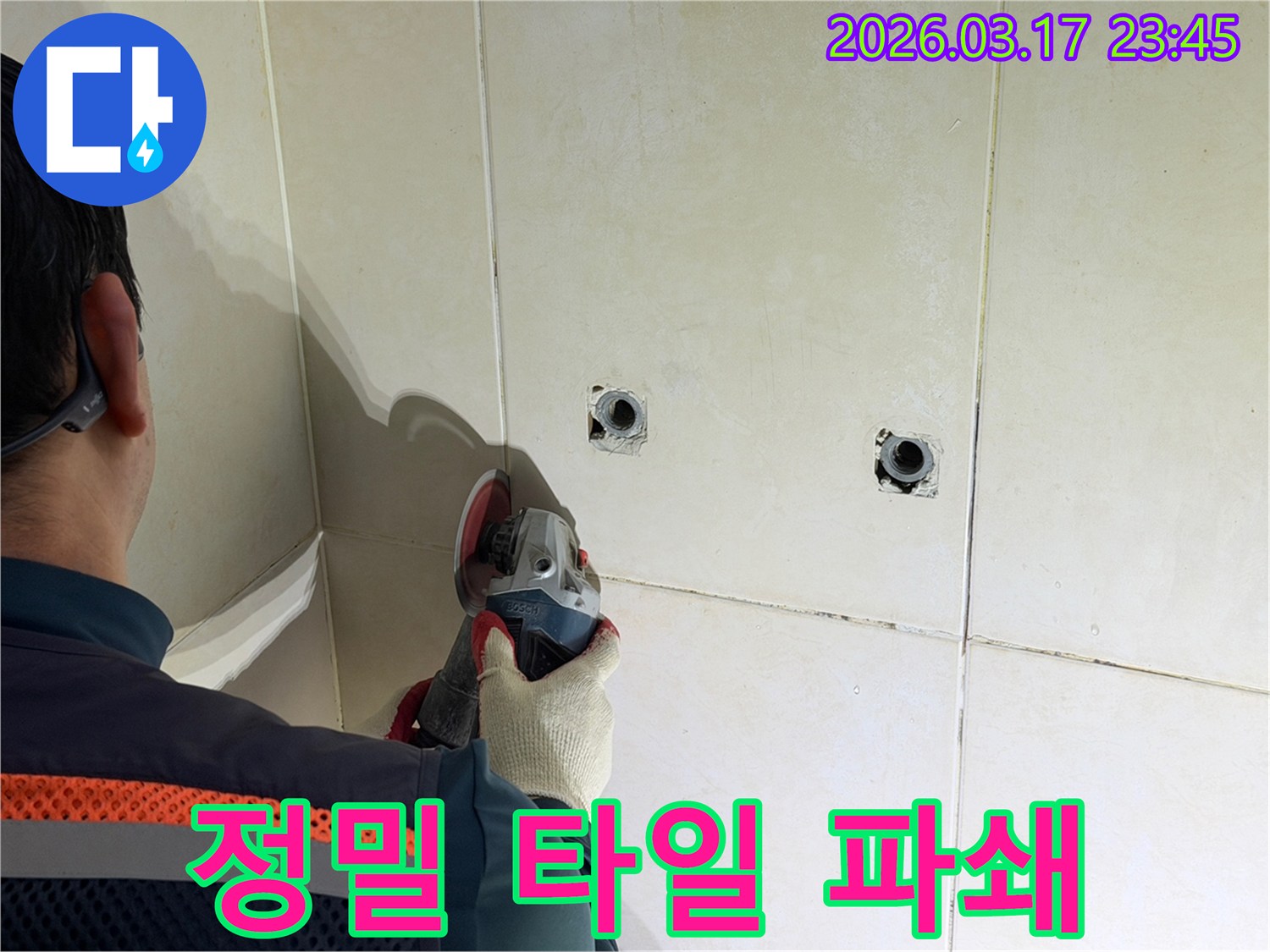 누수된 배관의-손상 부위를-정확히 확인하기 위해-전문가가-타일 벽면을-정밀하게-파쇄하는-작업을-진행하고-있습니다