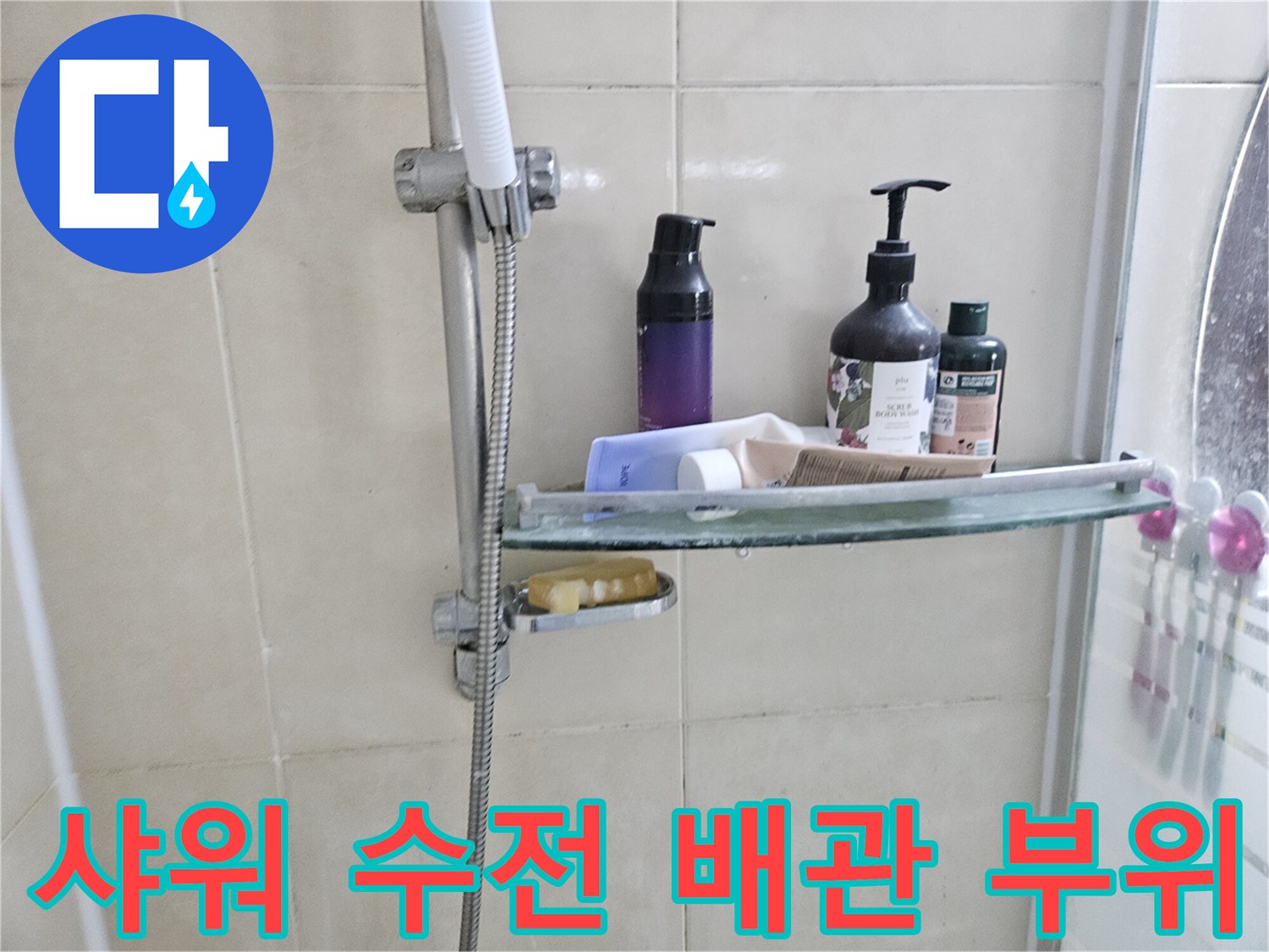 벽면 선반에 놓인 물품들과 샤워 호스 연결부