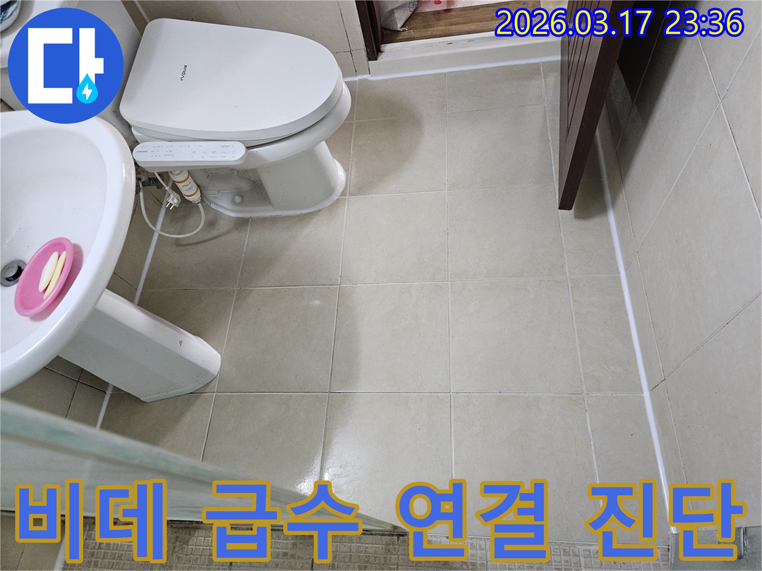 빌라 화장실 변기 옆 비데의 급수 연결부에서-미세한 누수 가능성 여부를-정밀하게 점검하는 모습입니다
