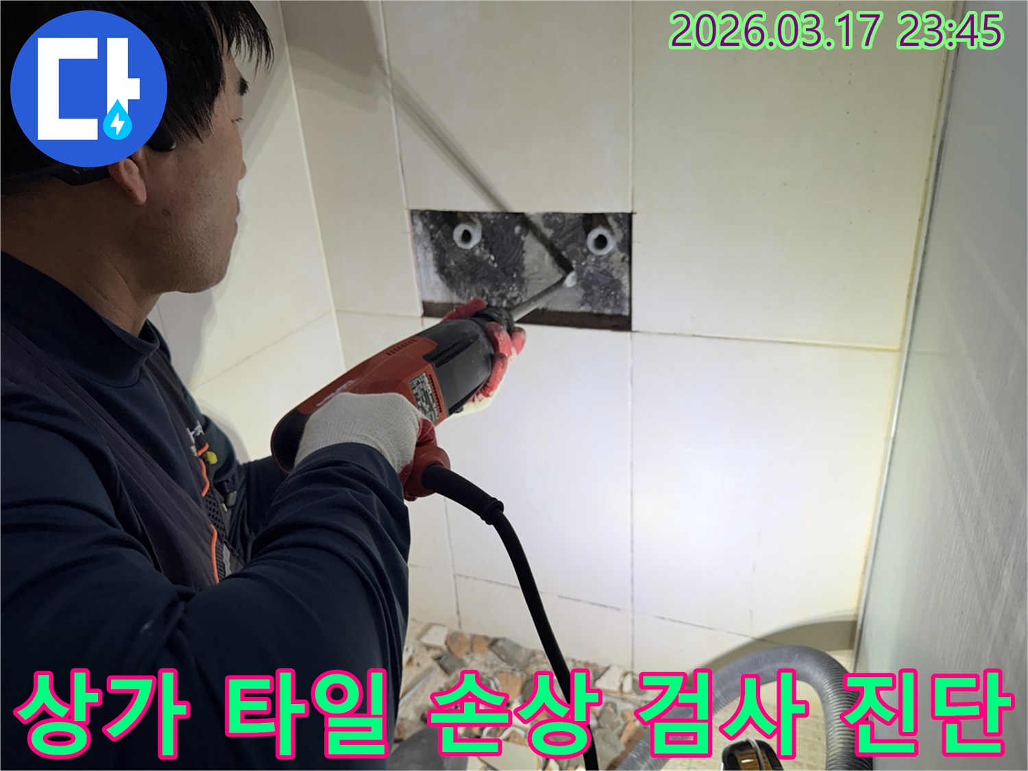숙련된 기술자가 상가 누수 지점을 찾아내기 위해-벽면 타일을 깨고 내부 배관의 손상 부위를 육안으로 검사하고 진단하는 작업을 진행하고 있습니다.