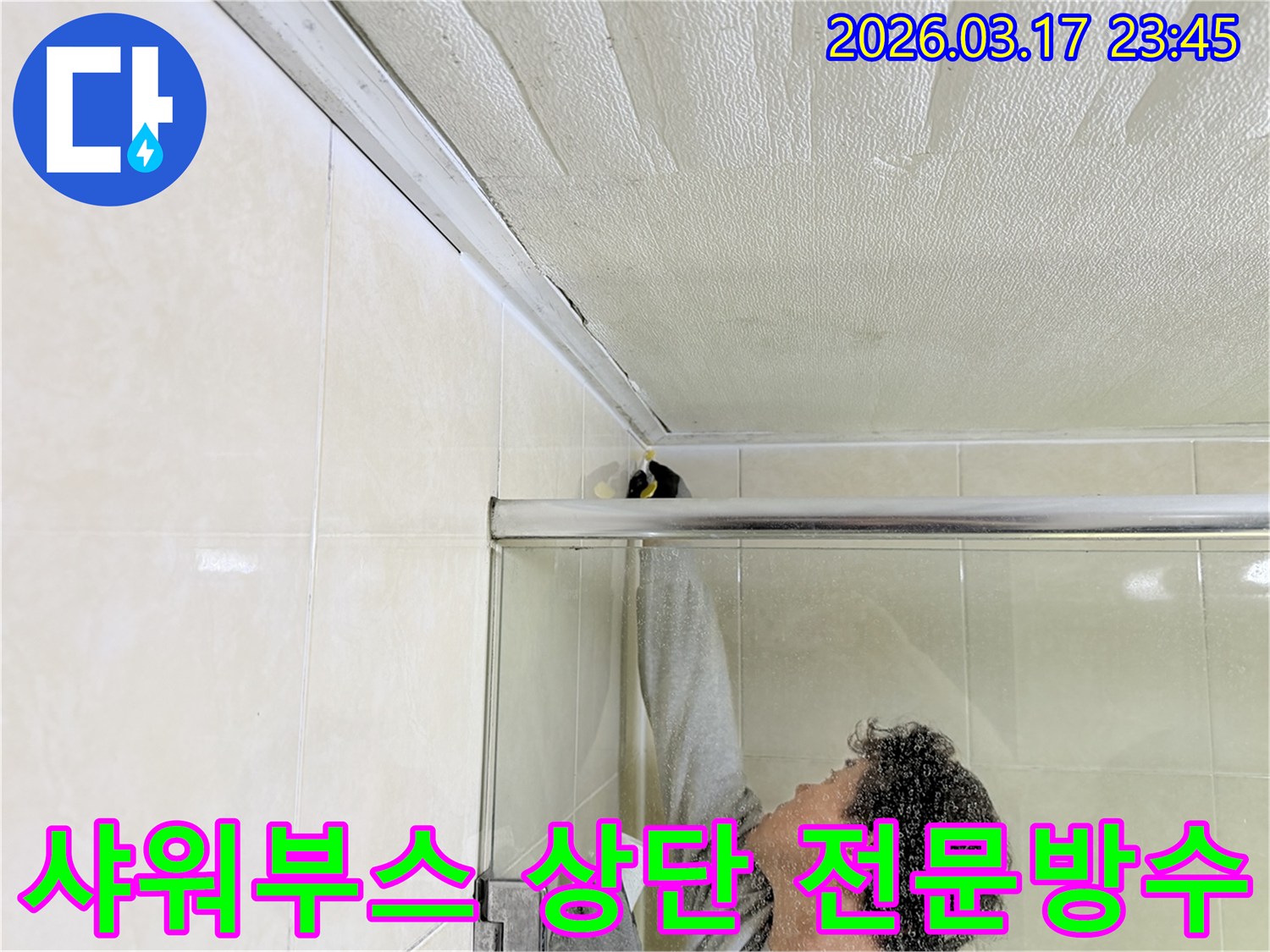 욕실 천장과 샤워부스 상단 틈새에서 발생한 누수를-전문 엔지니어가 꼼꼼하게 보수하는 모습입니다.