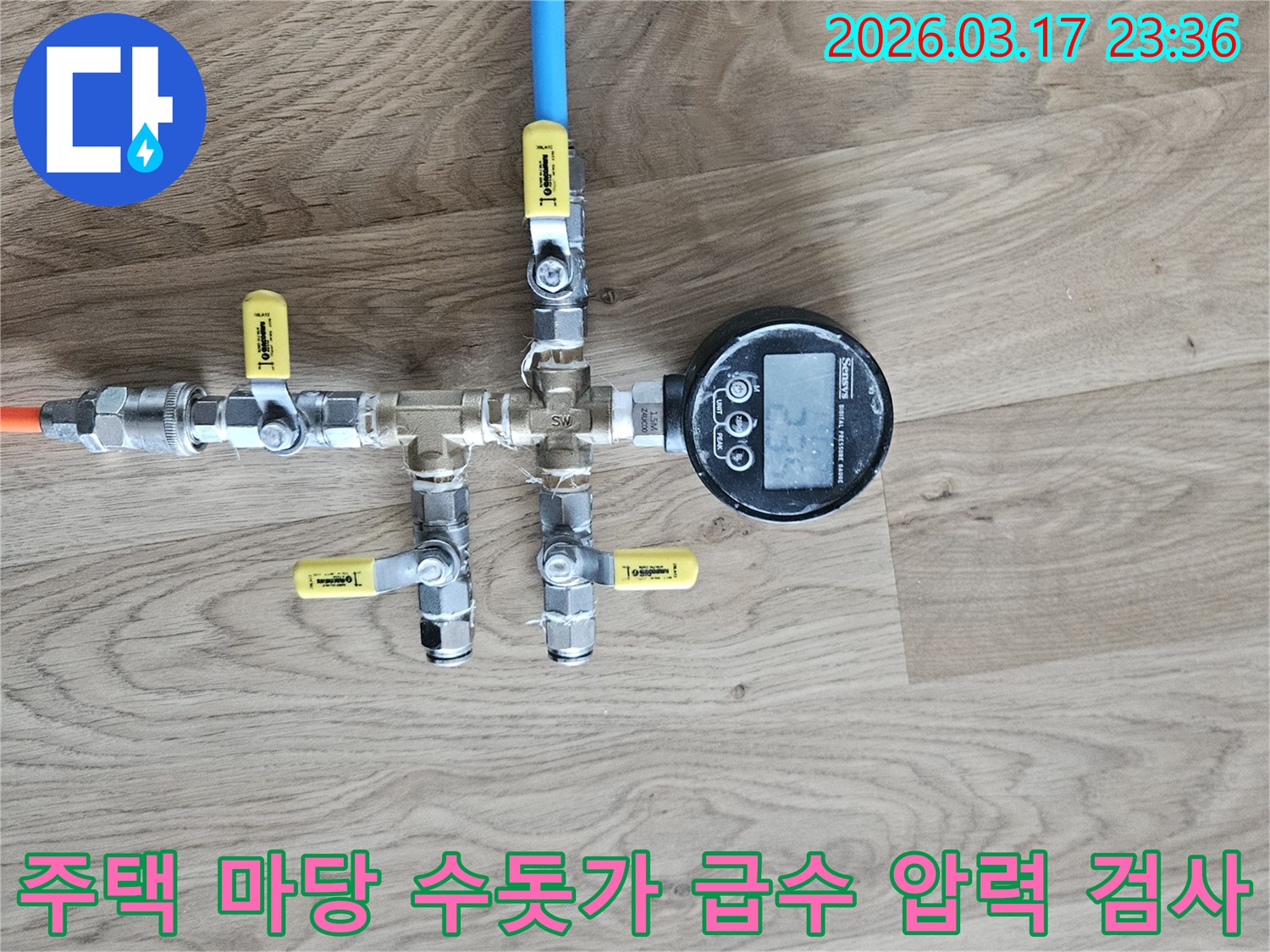 주택 마당 수돗가 급수 배관의 누수 여부를 확인하기 위해-정밀한 압력 테스트 장비를 연결하여-수치를 측정하고 있습니다.