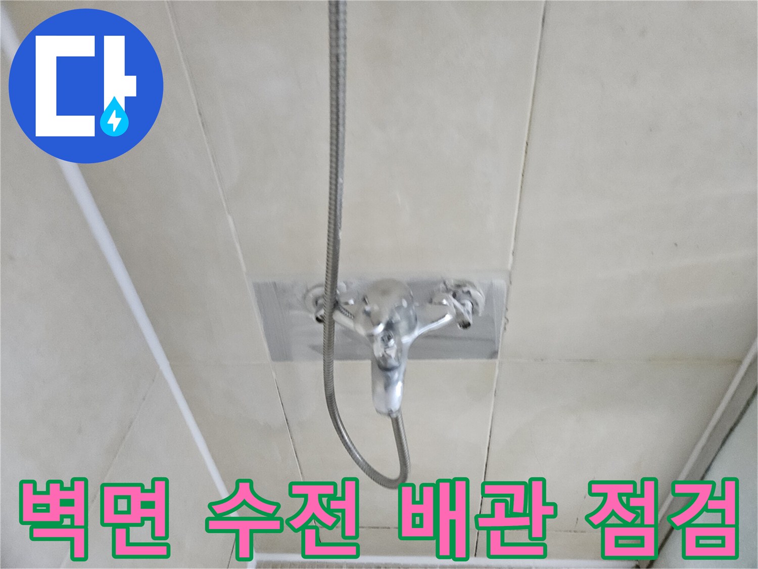 타일 벽면에 설치된 샤워 수전과 연결 호스 상세 이미지
