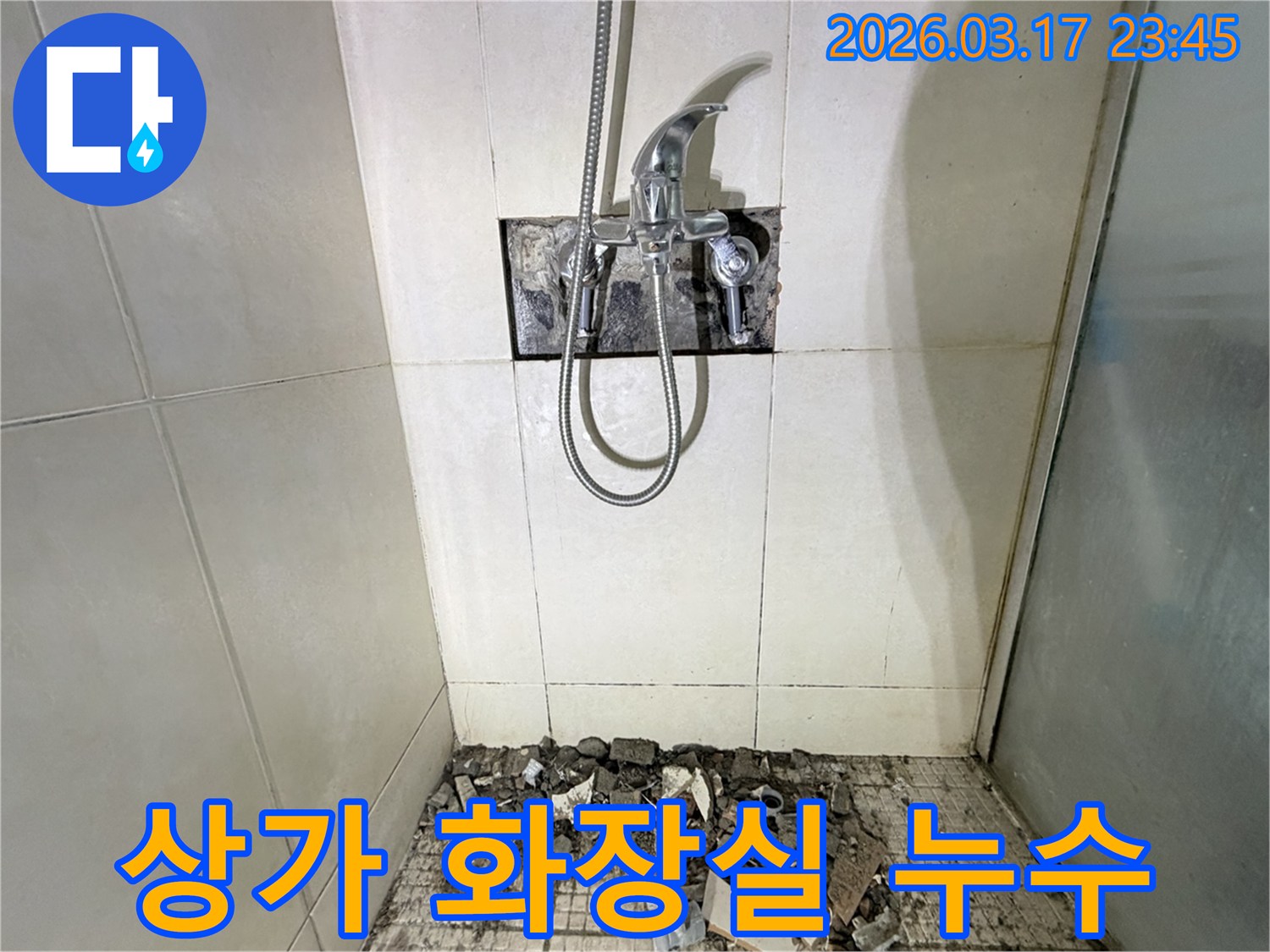 화성 병점동 상가 화장실에서-누수 원인 분석 및 해결을 위해-샤워 수전이 제거되고-바닥 타일이 파손된 채로-공사가 진행 중인 모습입니다.
