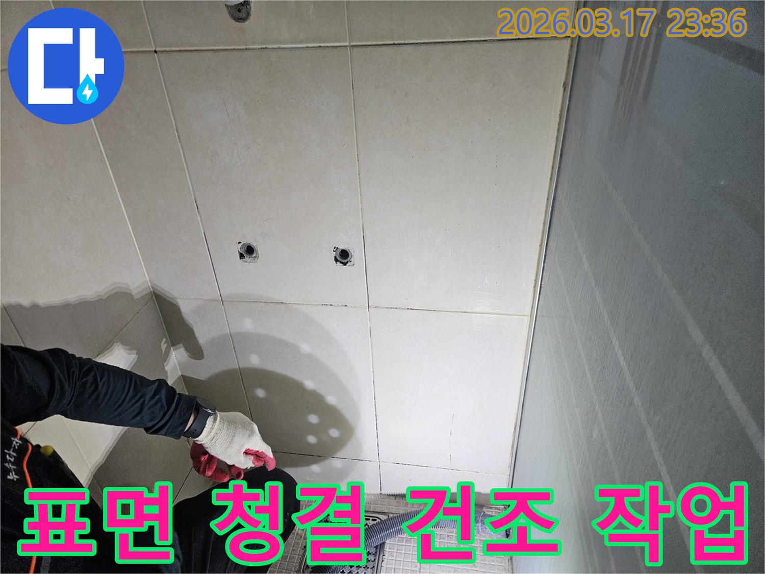 화성-병점동-샤워실에서-누수-보수-전-전문가가-표면을-청결하게-유지하고-건조하는-모습입니다