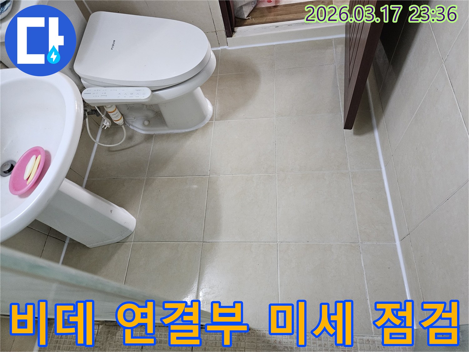 화장실 변기 옆 비데의 연결부와 급수관에서-미세한 누수 가능성 여부를-정밀하게 점검하는 모습입니다