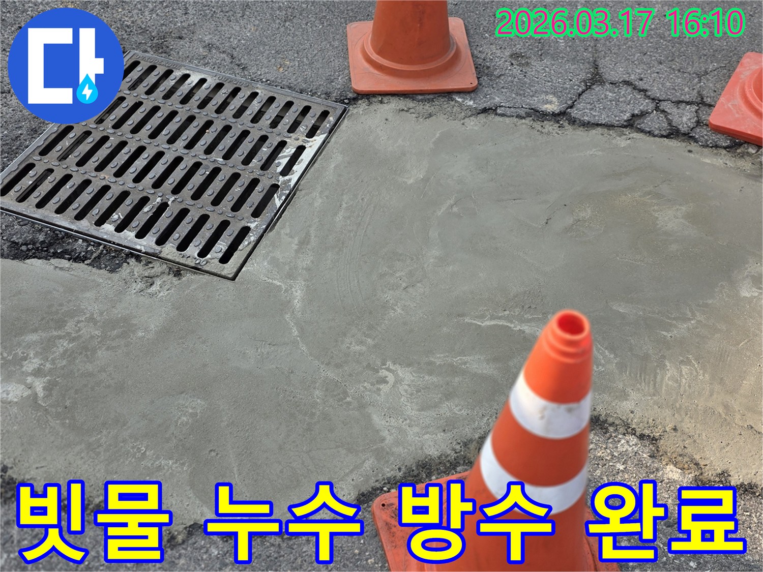 이 이미지는 양주 율정동의 빗물 누수 문제를 해결하고-배수구 주변에 방수 시멘트 마감을 완료한 현장을 보여주며-안전 콘이 설치되어 있습니다.