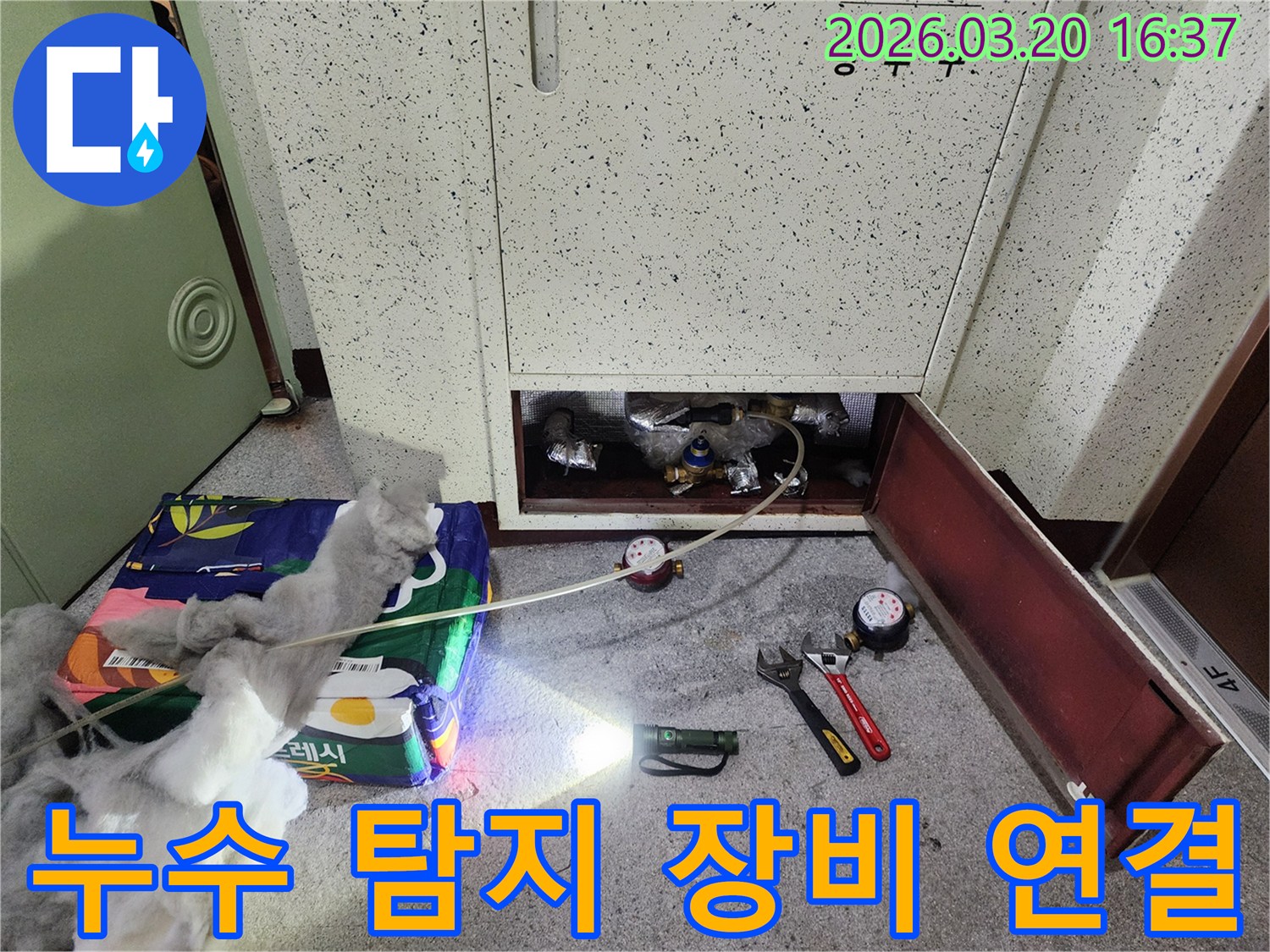 온수관 누수 지점을 찾기 위해-전문 탐지 장비를 연결하고-점검하는 모습입니다.