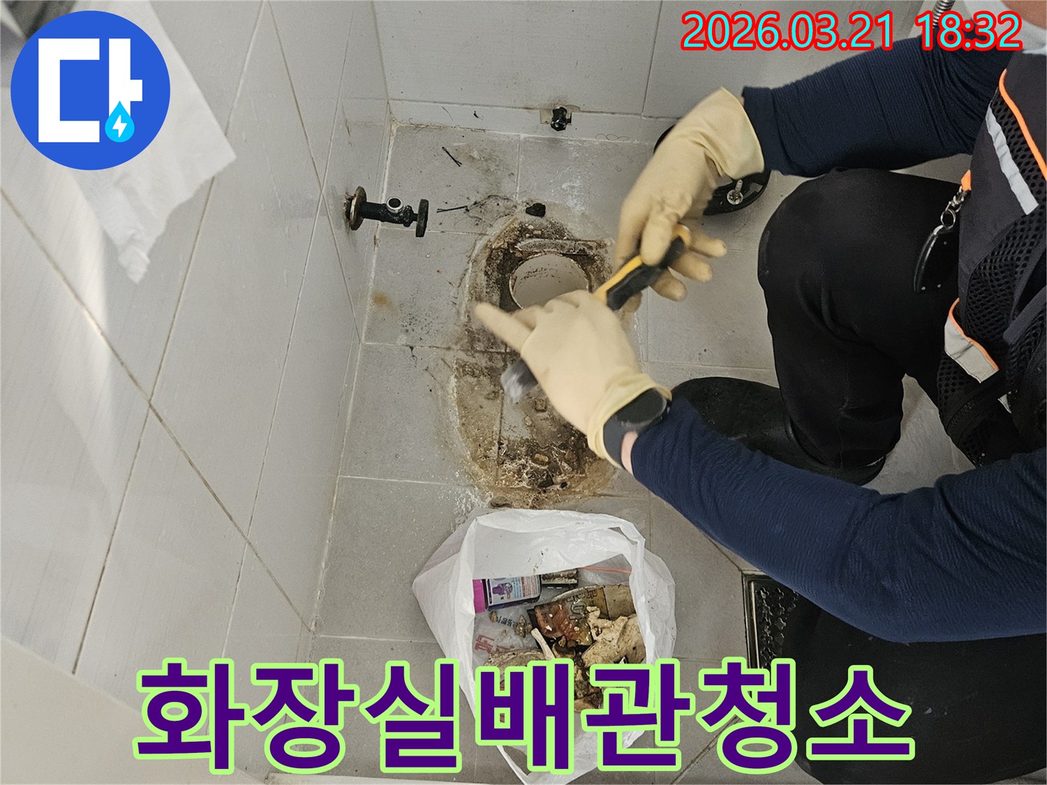 누수 엔지니어가-상가 화장실의-바닥 배관 주변에-쌓인 오염물질을-제거하며-보수 작업을-준비하고 있습니다