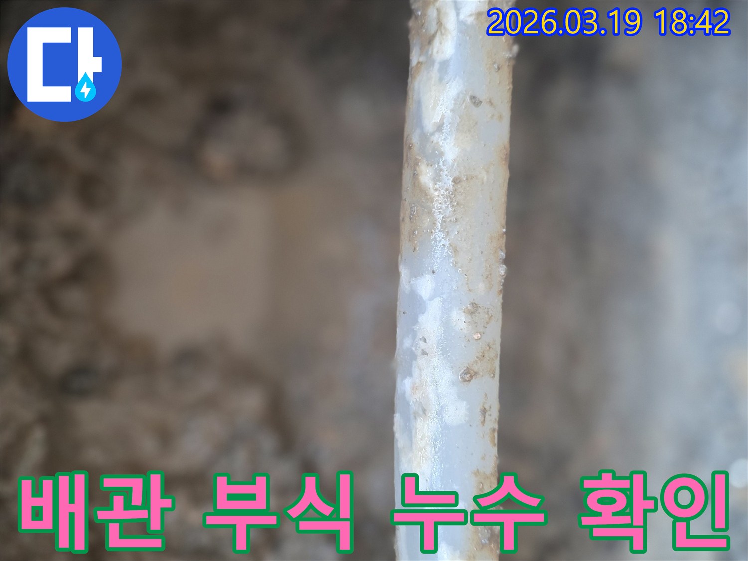 부식된 배관에서-물이 새어나와-주변에 물기가 고여있는-누수 상황을-보여주는 이미지입니다.