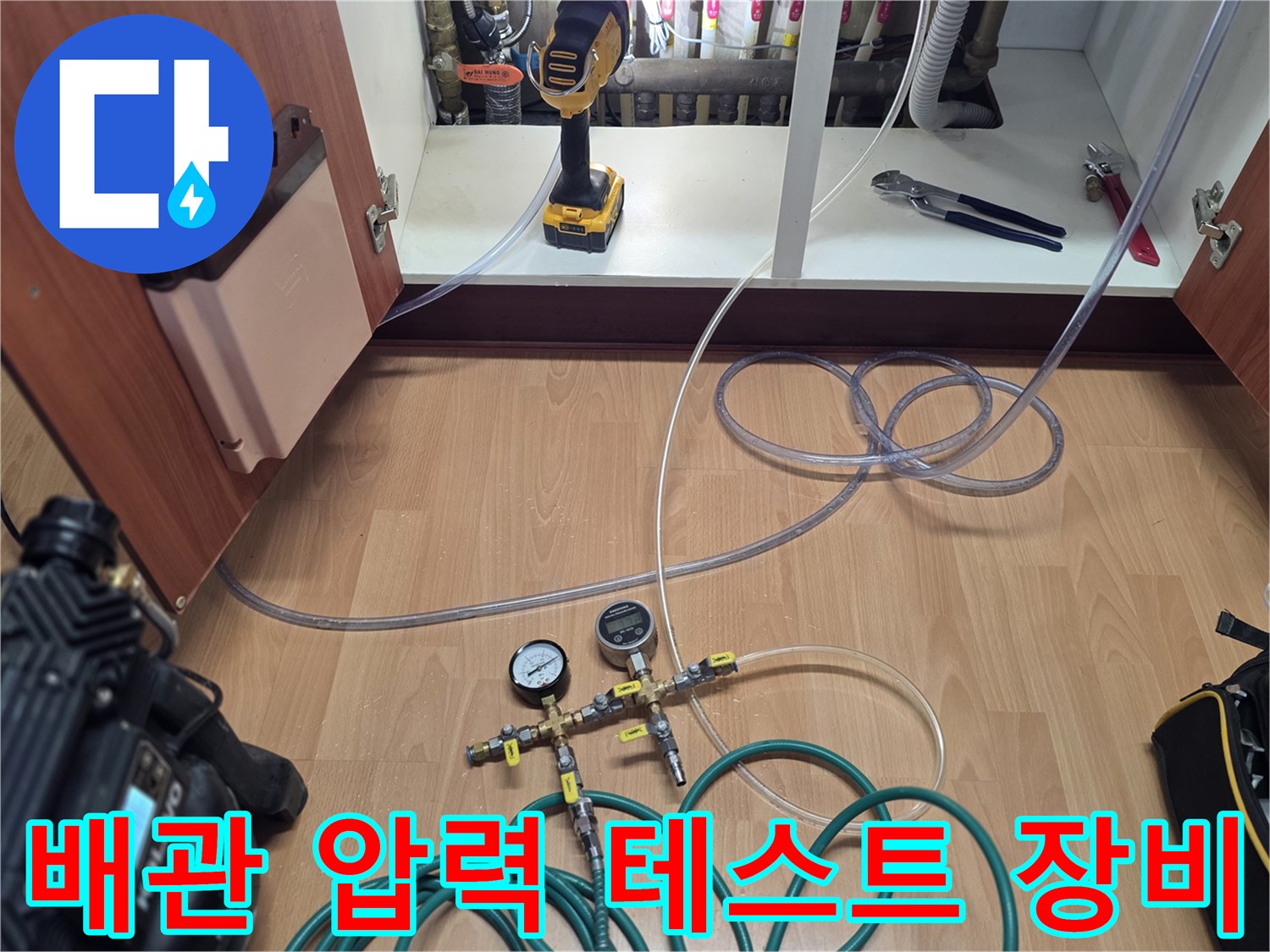 싱크대 하부 분배기-누수 진단을 위해 연결된 압력계와 공압 호스