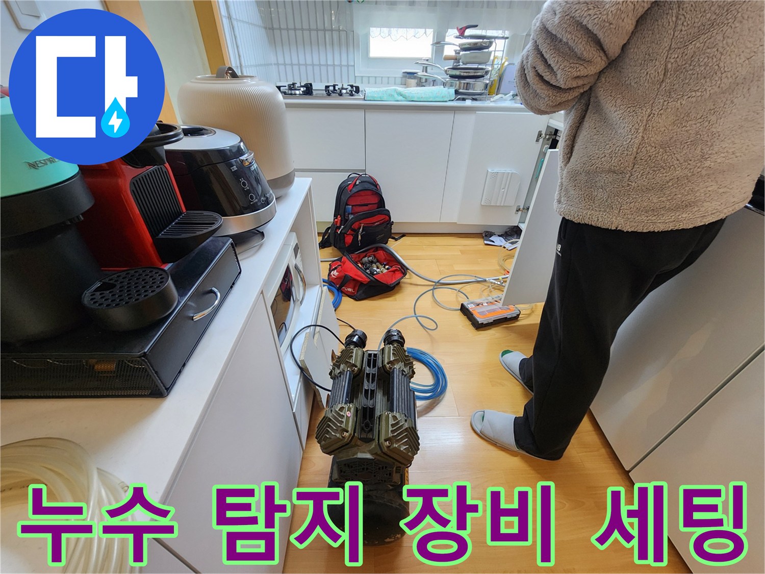 싱크대-하부장-바닥에-세팅된-배관-공압-테스트용-게이지와-호스