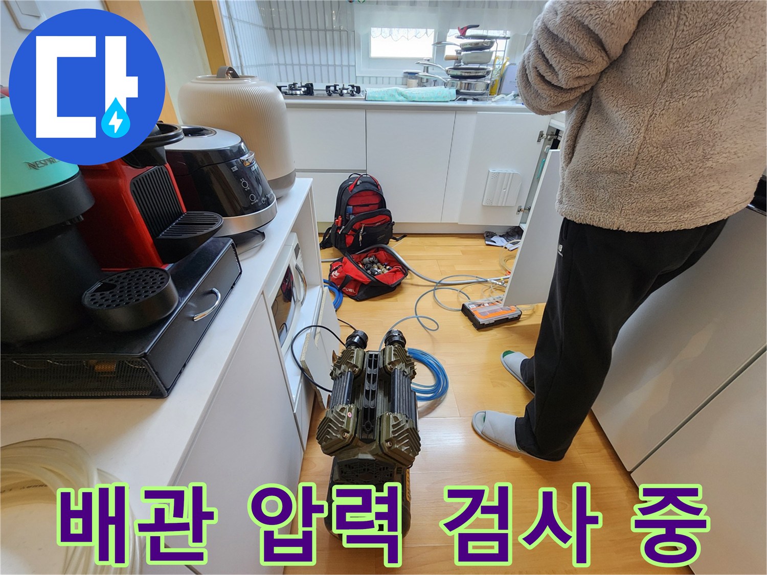 싱크대 하부장 바닥에서 진행되는 배관 공압 테스트 현장
