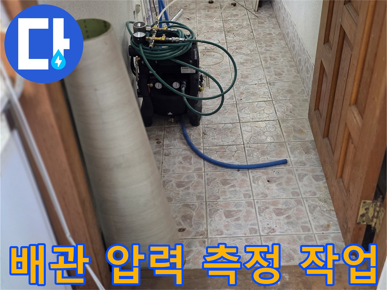 계량기함 내부의 복잡한 배관에 압력계를 연결하여 검사하는 장면입니다.