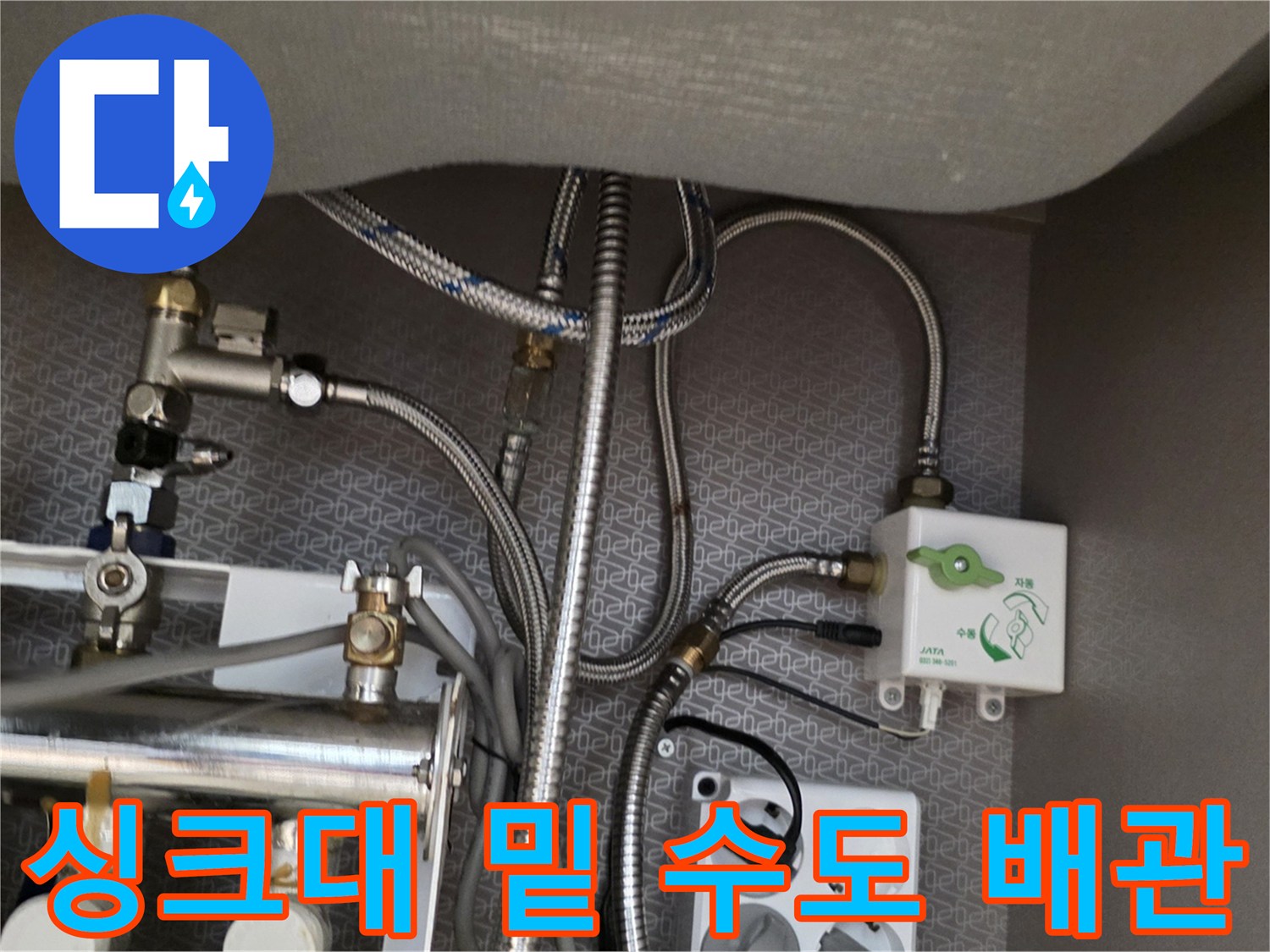 복잡하게 얽힌 싱크대 하단 금속 배관과 전선 및 콘센트 부근