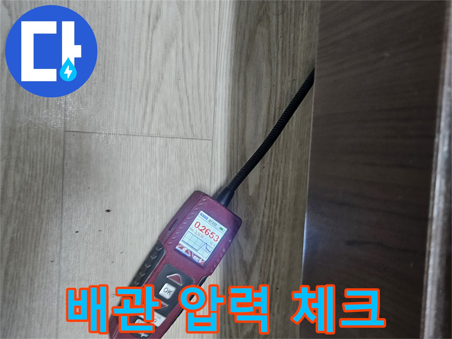 싱크대 밑 배관에 연결된 디지털 압력계의 수치 표시