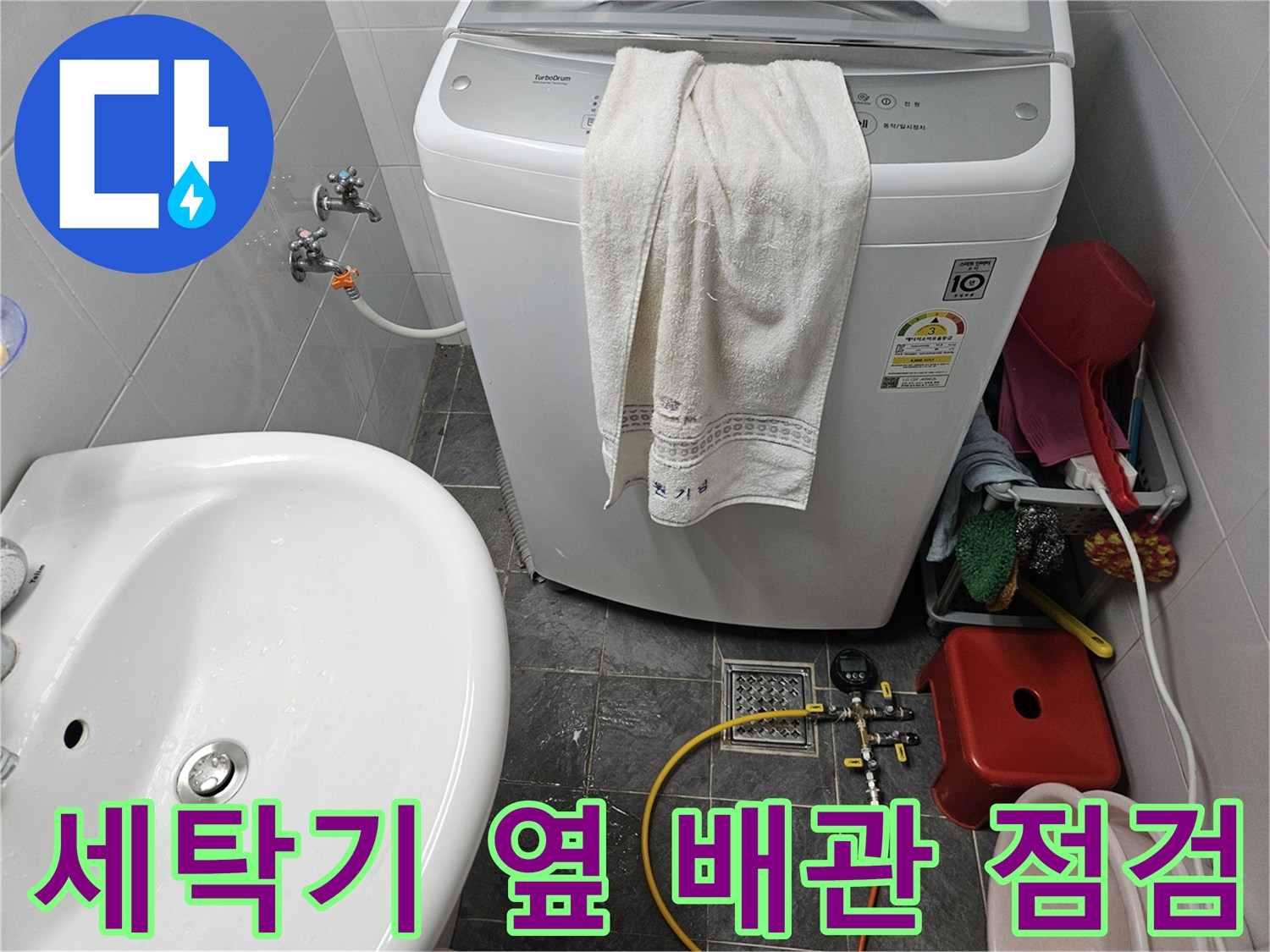 세탁기 주변의 수도 밸브와 디지털 압력계가 연결된 모습