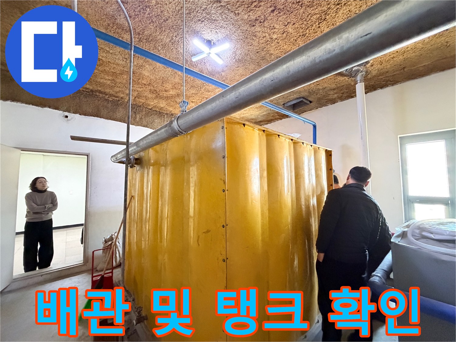 노란색 수조와 상부에 설치된 은색 배관의 모습입니다.