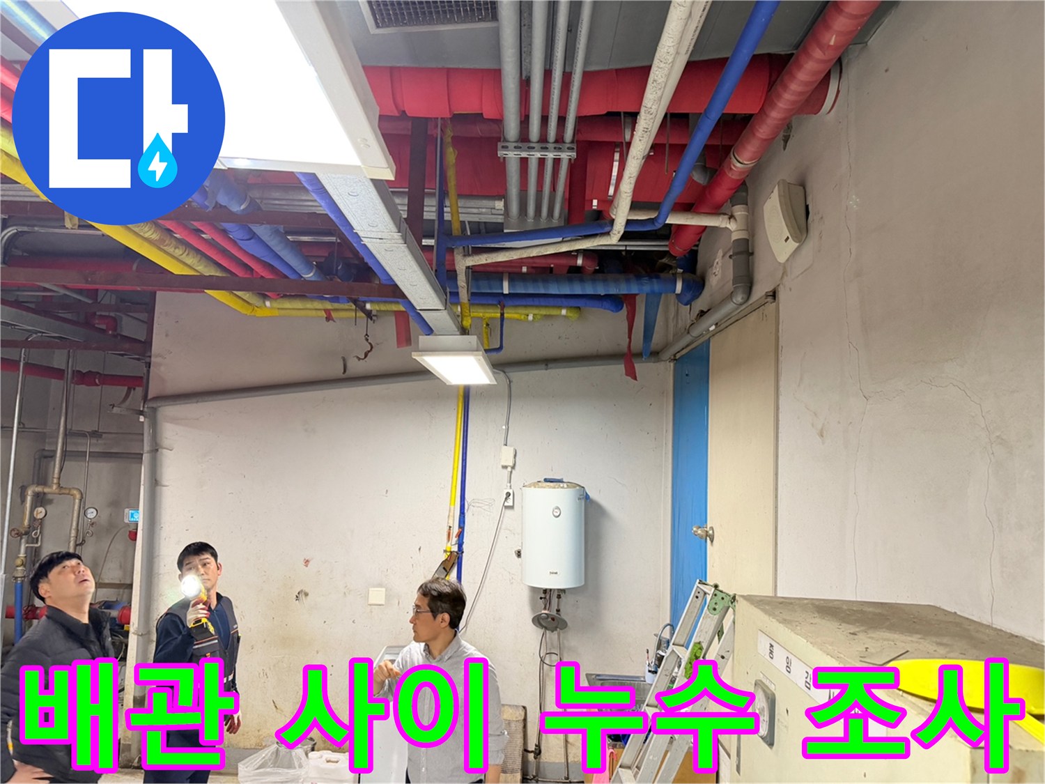 손전등을 들고 천장 배관의 접합부를 꼼꼼하게 살피는 작업 현장입니다.