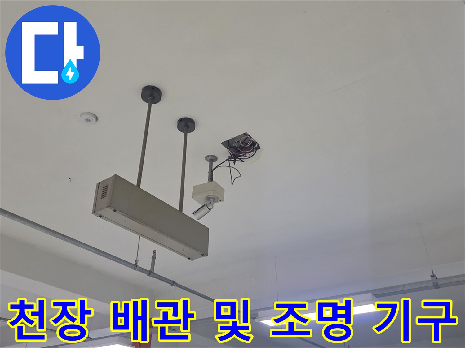 천장에 매달린 배관과 전선 연결 부위의 근접 촬영입니다.